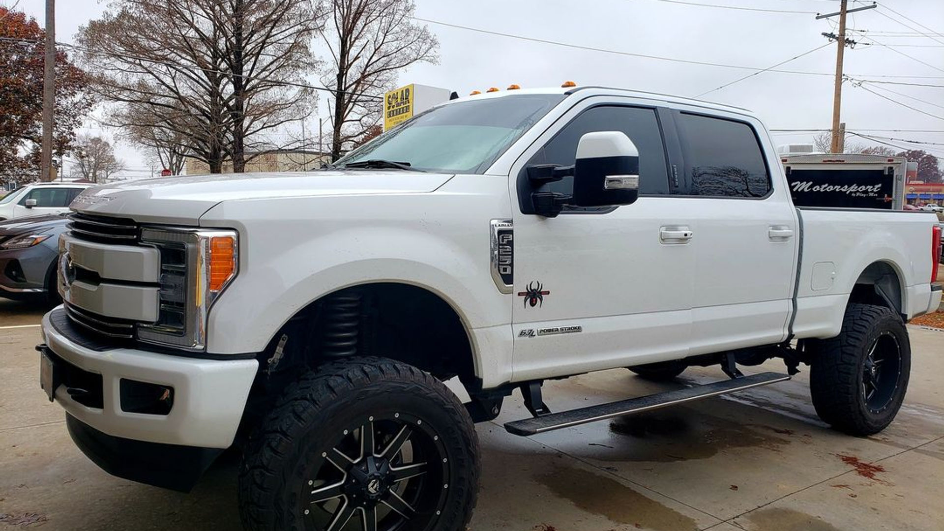 Lifted white Ford F-250 with tinted windows